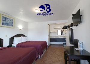 恩塞纳达港Hotel La Quinta Bonita的酒店客房配有两张床和一张书桌