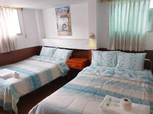 基多Hostal Benalcazar的酒店客房设有两张床和窗户。