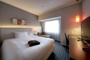 大分大分佛瑞扎酒店的酒店客房设有一张白色大床和一个窗户。