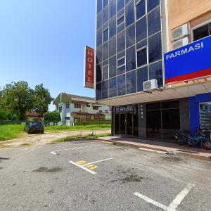 马六甲Park City Motel的大楼前的一个空停车位