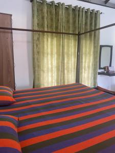 MalwanaSavenndra Resorts的一间卧室配有带条纹毯子的床