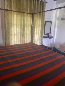MalwanaSavenndra Resorts的一间卧室配有一张带窗帘和地毯的床