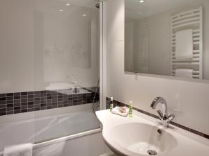 SolesmesGrand Hôtel de Solesmes - Teritoria的白色的浴室设有水槽和淋浴。