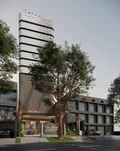 玛琅The Alana Hotel Malang的前面有棵树的办公楼
