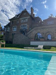 那慕尔Le loft du Castel Mosan的一座大房子,前面设有一个游泳池