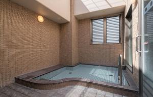 松山胜山甄选酒店的浴室角落的游泳池