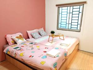 伯恩仓GWarmStay@GoldenHillsNightMarket的一间小卧室,配有一张桌子和一张床铺