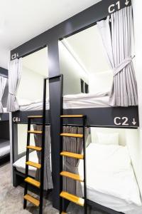 曼谷PIER 808 Hostel的双层床间设有两张双层床和梯子