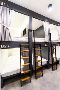 曼谷PIER 808 Hostel的带三张双层床和楼梯的客房