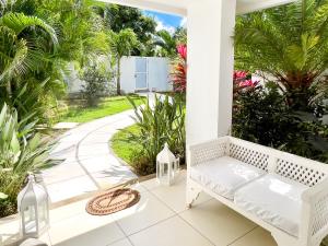 康隆尼角Villa White Horizon by Sealodge的棕榈树门廊上的白色长凳
