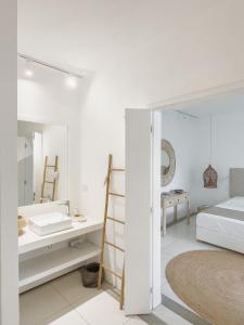 康隆尼角Villa White Horizon by Sealodge的白色卧室配有床和镜子