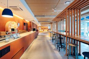 恩纳Hoshino Resorts BEB5 Okinawa Serakaki的餐厅设有长长的酒吧,配有凳子