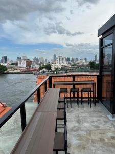 曼谷PIER 808 Hostel的一个带桌椅的市景甲板