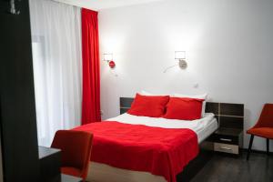 Cumpăna特拉斯吉拉斯皮斯科内格鲁旅馆的一间卧室配有红色床单和红色枕头。