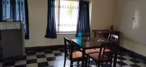 海得拉巴The Ghosh's Home stay的一间带桌椅和窗户的用餐室