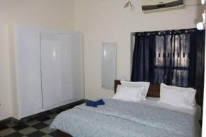 海得拉巴The Ghosh's Home stay的一间卧室配有一张带蓝色丝带的床