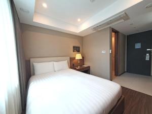 釜山釜山商务酒店的卧室设有一张白色大床和一扇窗户。