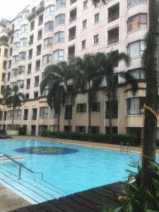 马尼拉1BR Condo at Montecito Newport City Residential Resort across NAIA and Marriott Hotel的大楼前的大型蓝色游泳池