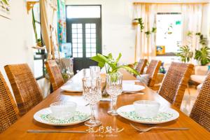 马公澎湖旅行路上民宿/私厨的一张木桌,上面有盘子和玻璃杯