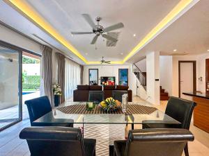 邦涛海滩Wonderful villa Harmony BangTao beach的客厅配有吊扇和桌椅