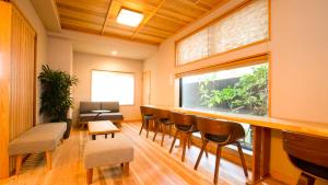 福冈NK Hotels的客房设有带椅子的酒吧和窗户。
