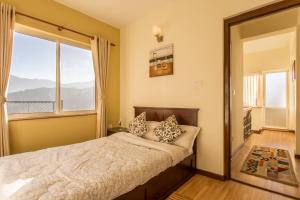 加德满都斯塔帕拉瓦亚布公寓酒店 的一间卧室设有一张床和一个大窗户