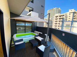福冈NK Hotels的一个带遮阳伞和游泳池的阳台