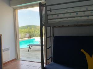 Durban-CorbièresVilla Corbieres的一间卧室配有一张双层床,享有游泳池的景色
