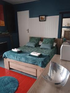 布里阿尔Marie-Claire la grillade的一间卧室配有两张蓝色墙壁的床和一张桌子