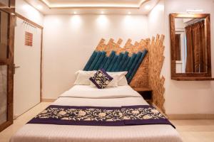 布莱尔港Ananya Residency的一间卧室配有一张蓝色床头板的床