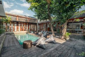 塞米亚克Batu Belig Living Managed by CPM Bali的坐在游泳池旁的房子里的人