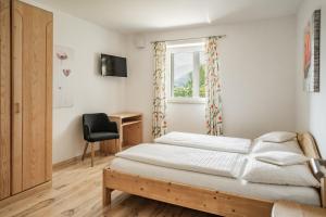 沃兰Falgerhof的一间卧室配有一张床、一张书桌和一个窗户。