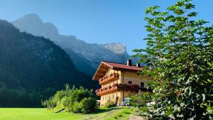 维尔芬翁Alpen Appartements Oberlehengut - HIDEAWAY的山丘上的建筑,背景是山脉