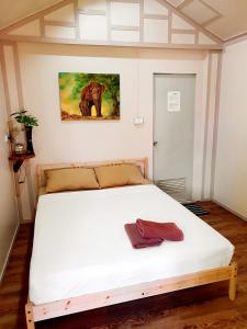 象岛Jungle View Resort的卧室配有一张白色床,墙上挂有绘画作品