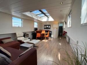 阿姆斯特丹Spacious homely house boat的一间带天窗的客厅和一间带桌子的房间
