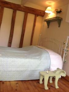 MazièresDomaine Charente - Familyroom Gypsy with garden (with external toilet & shower house)的卧室配有白色的床和桌子