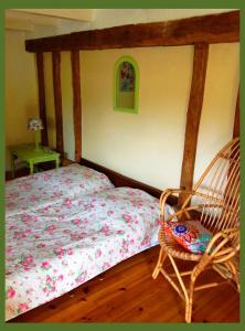 MazièresDomaine Charente - Familyroom Gypsy with garden (with external toilet & shower house)的一间卧室配有一张床和一把摇椅
