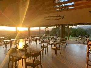 克拉格斯Crags Country Lodge的餐厅设有桌椅,享有日落美景。