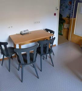 特拉本特拉巴赫Monkey Factory - Mini Home-Stay Hostel的一张木桌,带四把椅子