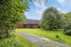 永比Nice cottage in Bolmstad outside Ljungby的前面有一条碎石路的红谷仓