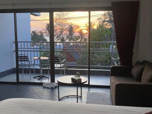 卡马拉海滩Deng's kamala beach Guesthouse的带沙发的客厅和阳台美景