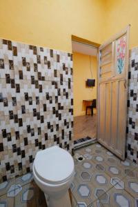 PalopoWisma Pelangi Palopo RedPartner的一间带卫生间和瓷砖墙的浴室