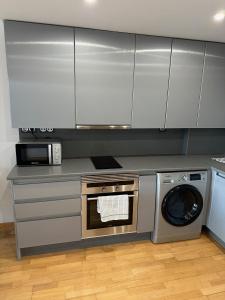 马德里Loft_Luminoso_Efeso的厨房配有洗衣机和微波炉。