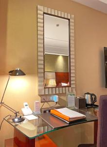 上海上海美丽园大酒店(原上海美丽园龙都大酒店)的一张位于酒店客房内的桌子,配有一盏灯和一面镜子