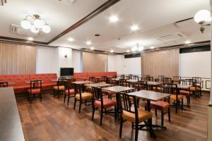 四日市Hotel Castle Inn Yokkaichi的一间会议室,配有桌椅和屏幕