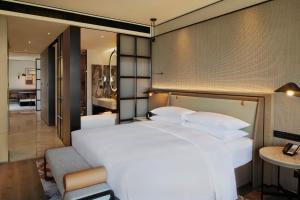 台州台州喜来登酒店的一间带白色大床的卧室和一间客厅