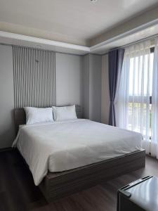 Thôn Dương PhẩmThiên Ân Hotel的卧室配有一张大白色床和窗户