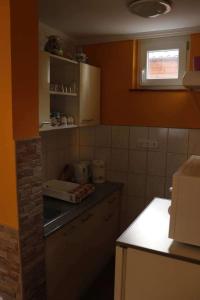博加奇Hócza Apartman的厨房设有橙色墙壁和台面
