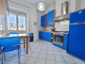 斯培西亚Brezza d'Estate - L'Opera Group的厨房配有蓝色橱柜、桌子和蓝色椅子