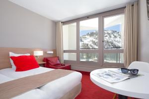伊索拉2000SOWELL HOTELS Le Pas du Loup的酒店客房设有一张床和一个大窗户